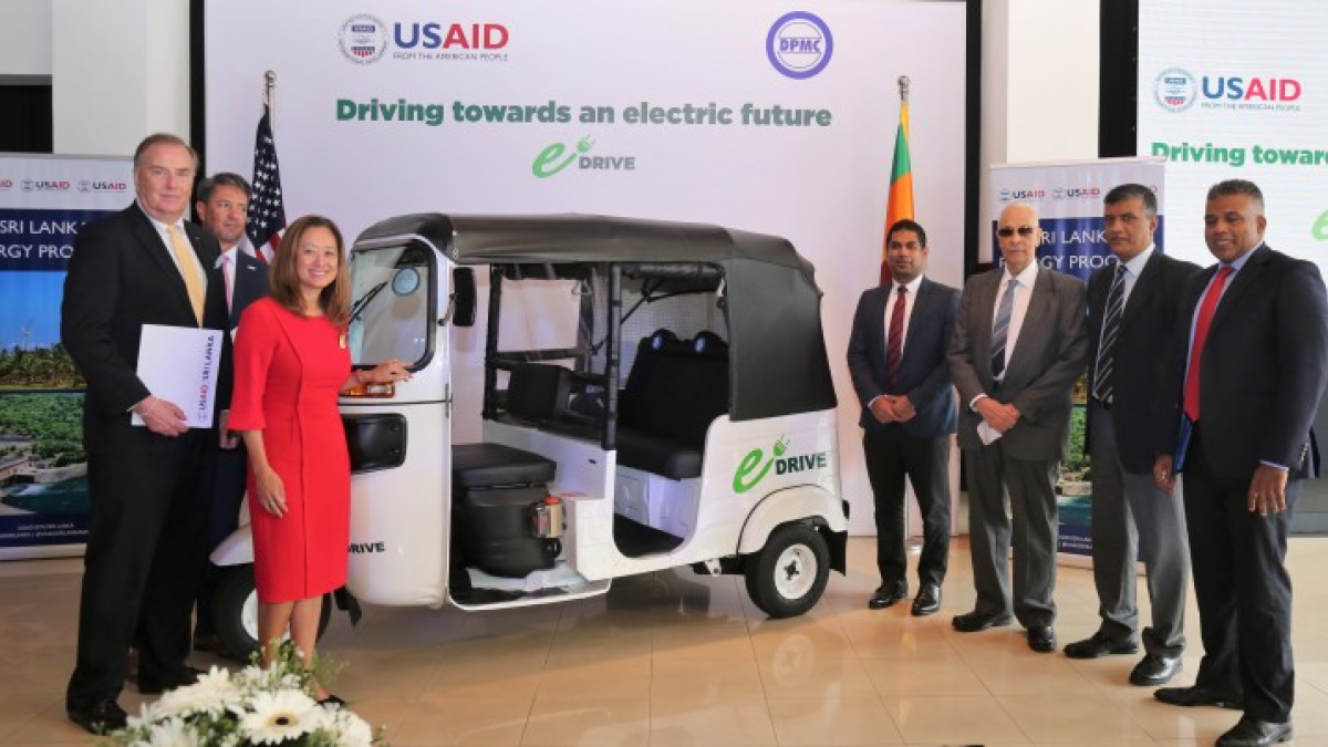 Representatives from USAID Sri Lanka and David Pieris Motor Company standing with a tuk tuk