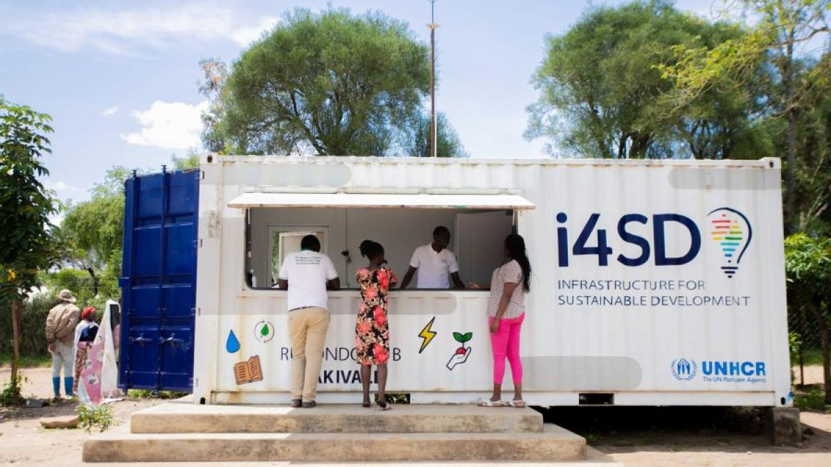 People standing in front of a Infrastructure for Sustainable Development (i4SD) kiosk.
