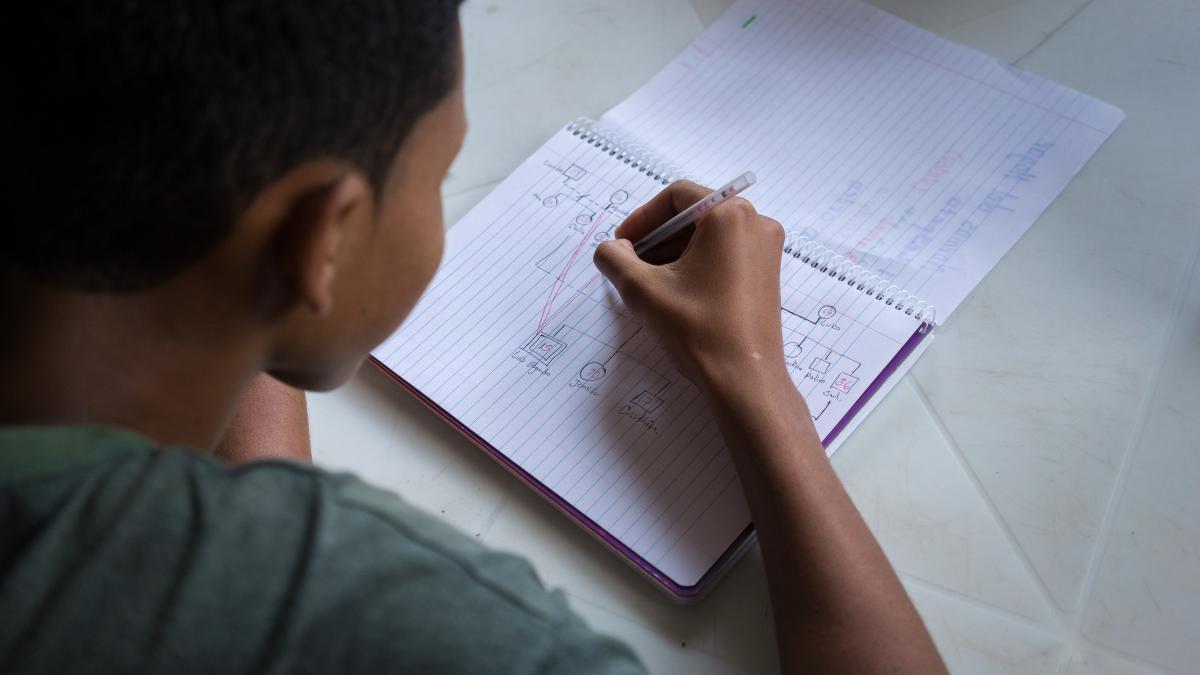 A boy writes in a notebook