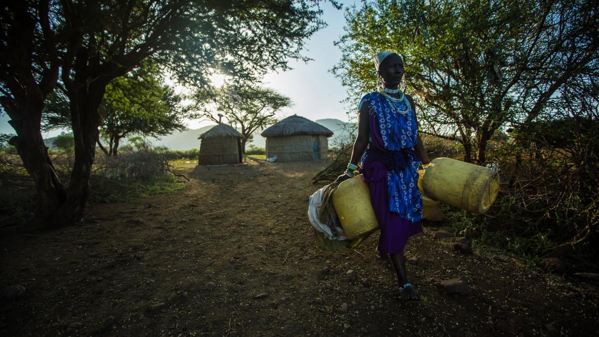 A woman carries water buckets in Tanzania