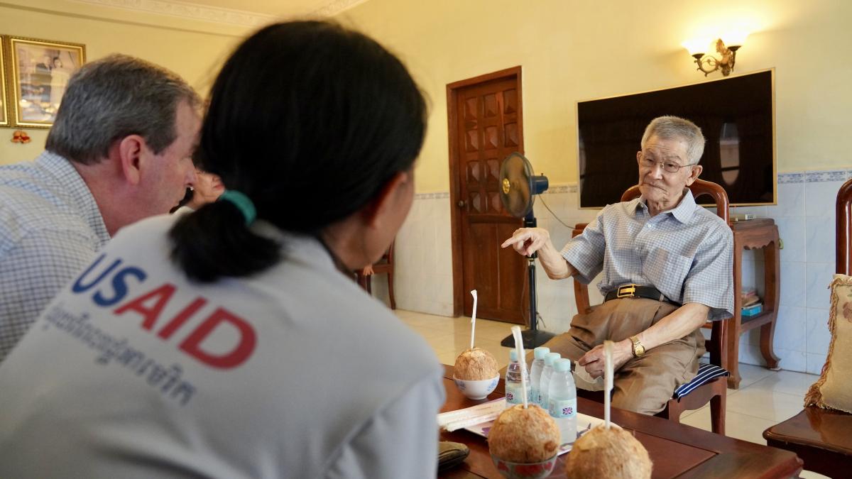 Yeang Chheang speaks with USAID and U.S. President’s Malaria Initiative staff at his home in Phnom Penh.