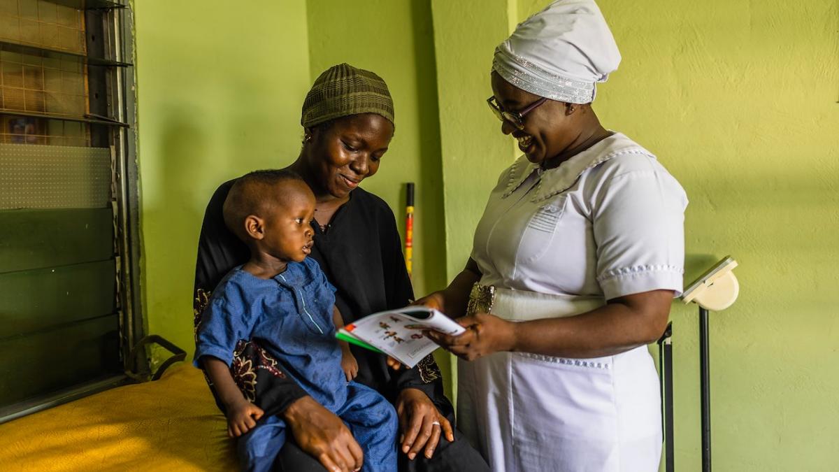 A woman and her child are attended to in Adama’s office where she conducts checkups, writes care plans, monitors and administers medication, such as antimalarials, and offers parents and caregivers advice on the care of newborns.