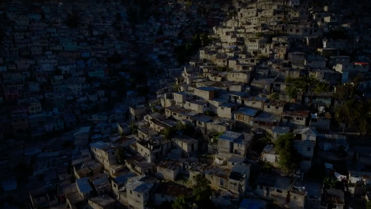 A wide angle image of a Haitian town with residences on a hill.
