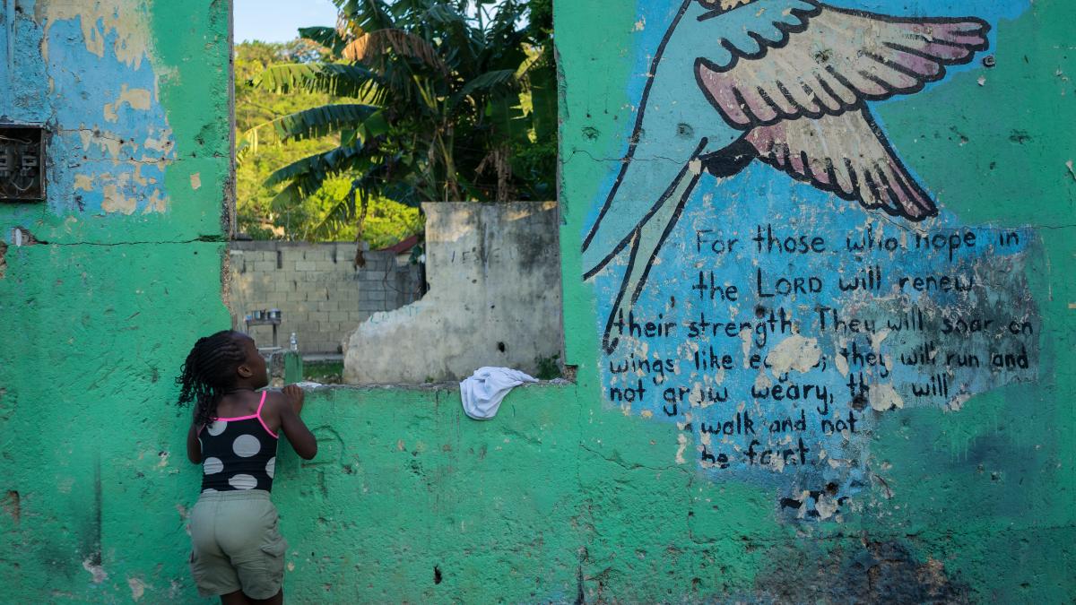 A child looks up at a local mural.