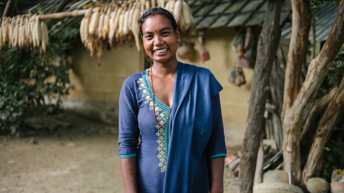 A woman in native Nepali dress smiles for the camera