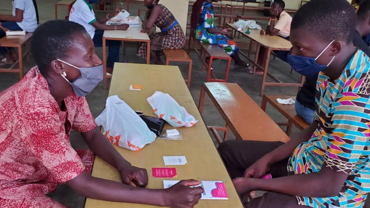 A teacher (left) and her son (right) in Lomé, Togo, use the community adaptation of Empathways to discuss adults’ role in increasing youth access to FP/RH information and services.