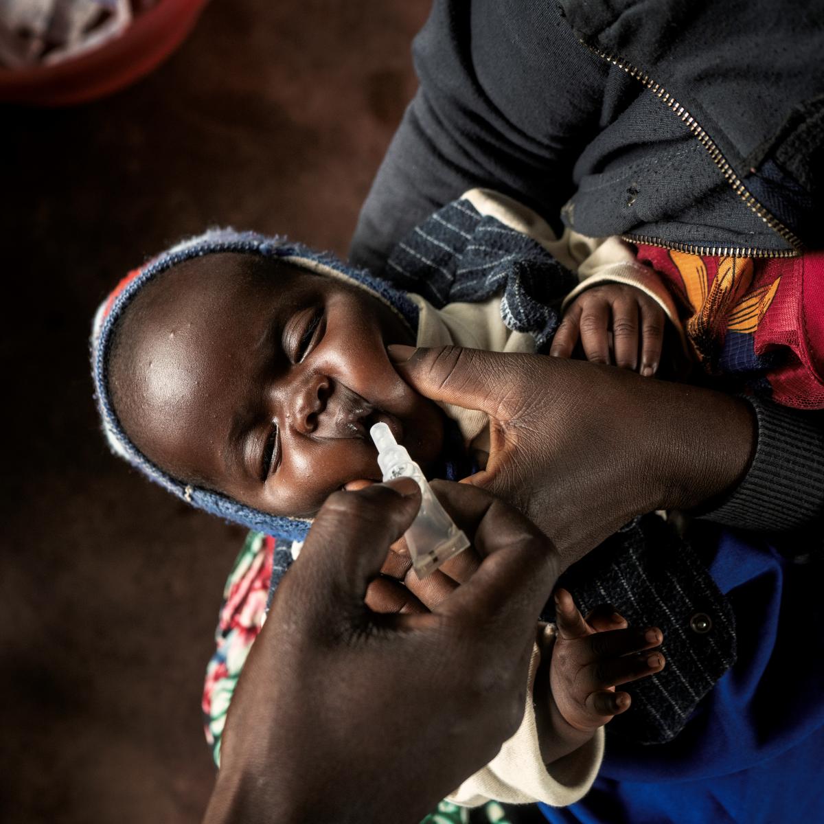 Photo of a newborn child receiving an oral vaccine. 