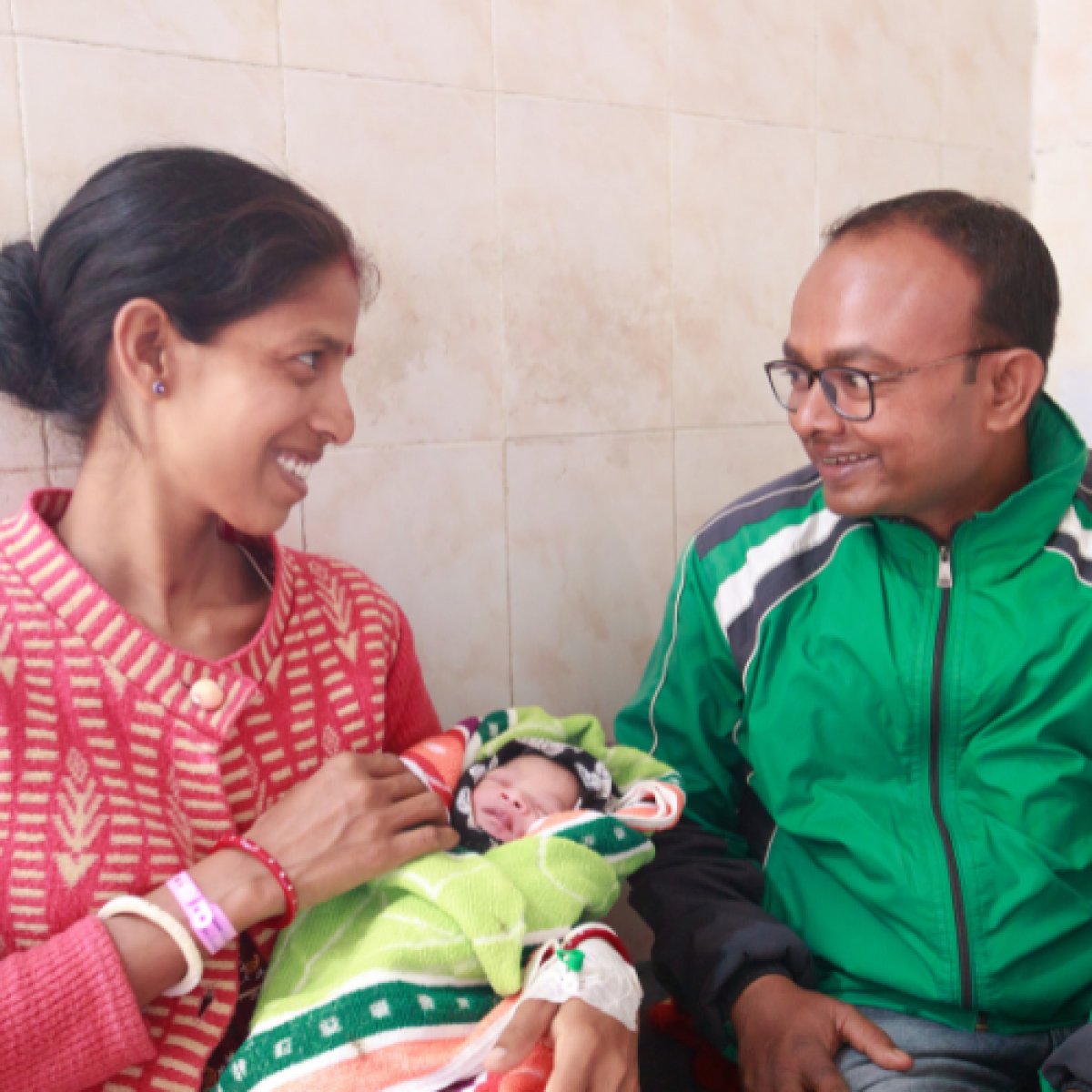 Shivani (left) and Amit (right) admire their new baby at the Ranchi District Hospital in India.