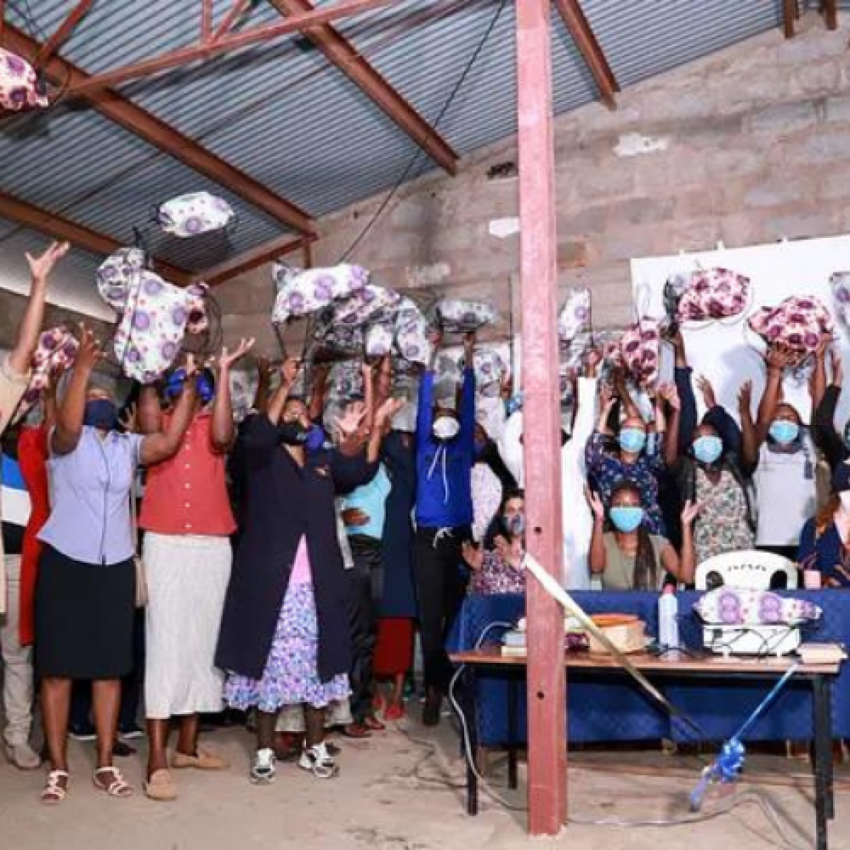 Women employees in Kenya with their locally manufactured bag that includes locally sourced, disposable and reusable menstrual products and underwear.
