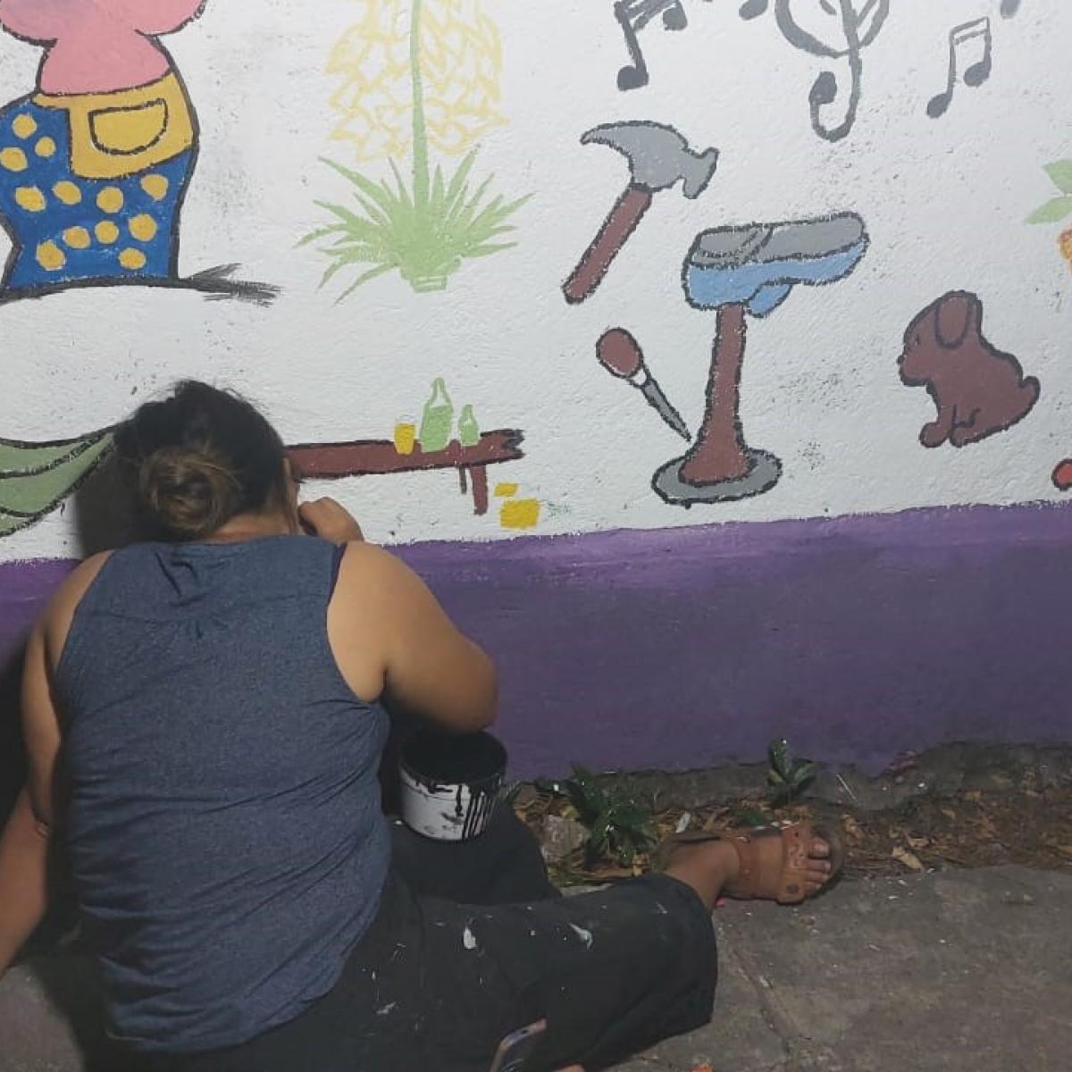 Woman painting a mural in La Presita I 