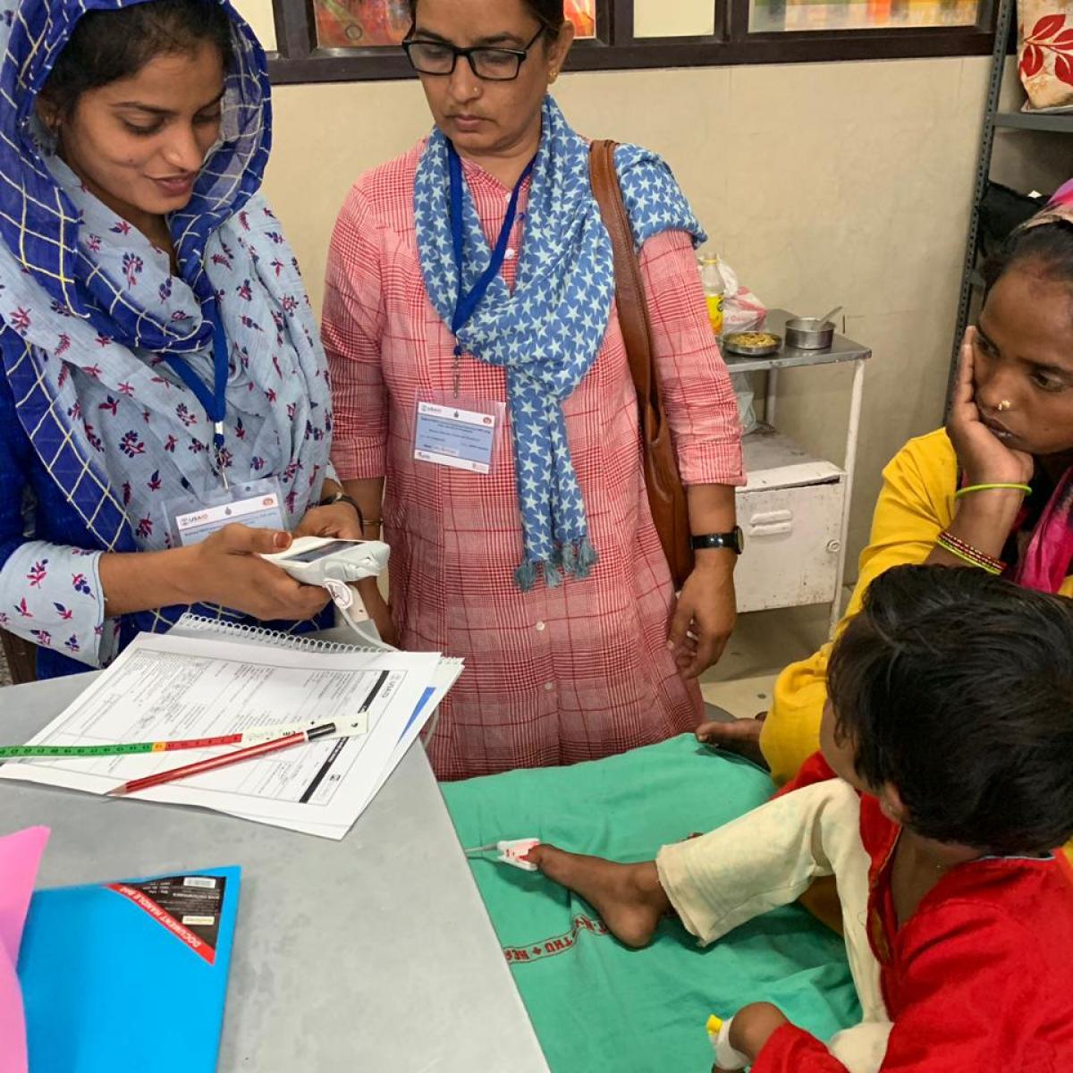 Community health officer Mumtaz Bano uses a multimodal pulse oximeter to determine whether a child has pneumonia.