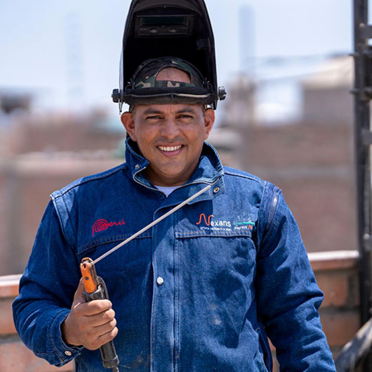 A worker man smiling and holding a welding tool