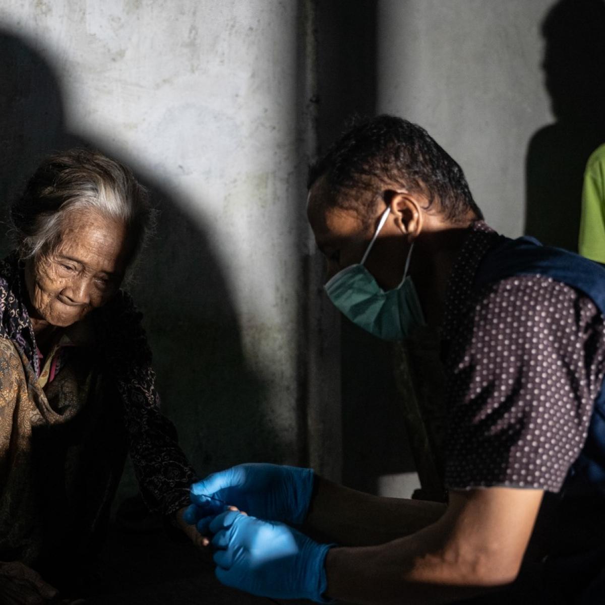 A health worker draws blood from residents to test for lymphatic filariasis in several villages in Melawi. Photo: RTI International/Oscar Siagian