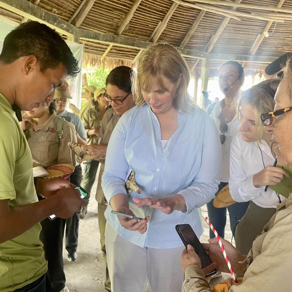Indigenous People showing USAID Mission Director how they use technology to monitor their lands
