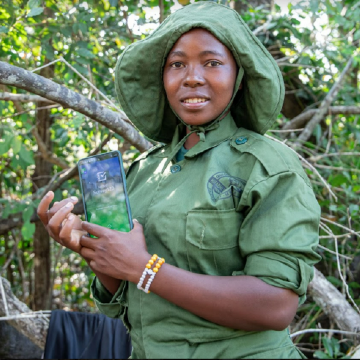Photo: Amina Hussein, the Kambuzi Halt village forest monitor, displays how a smartphone is used to capture forest threats in village forest reserves in the Katumba Settlement.