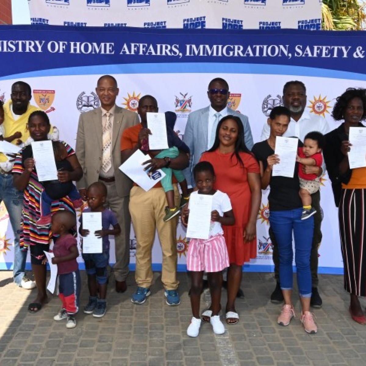 In the background center from left to right: Dr. Abeje Zegeye (HIV Advisor, USAID Namibia), Jackson Wandjva (Deputy Executive Director of the Ministry of Home Affairs, Immigration, Safety and Security) and Nanyemba Katamba (Deputy Chief of Party NARP, Project Hope Namibia) with children who received their birth certificate.