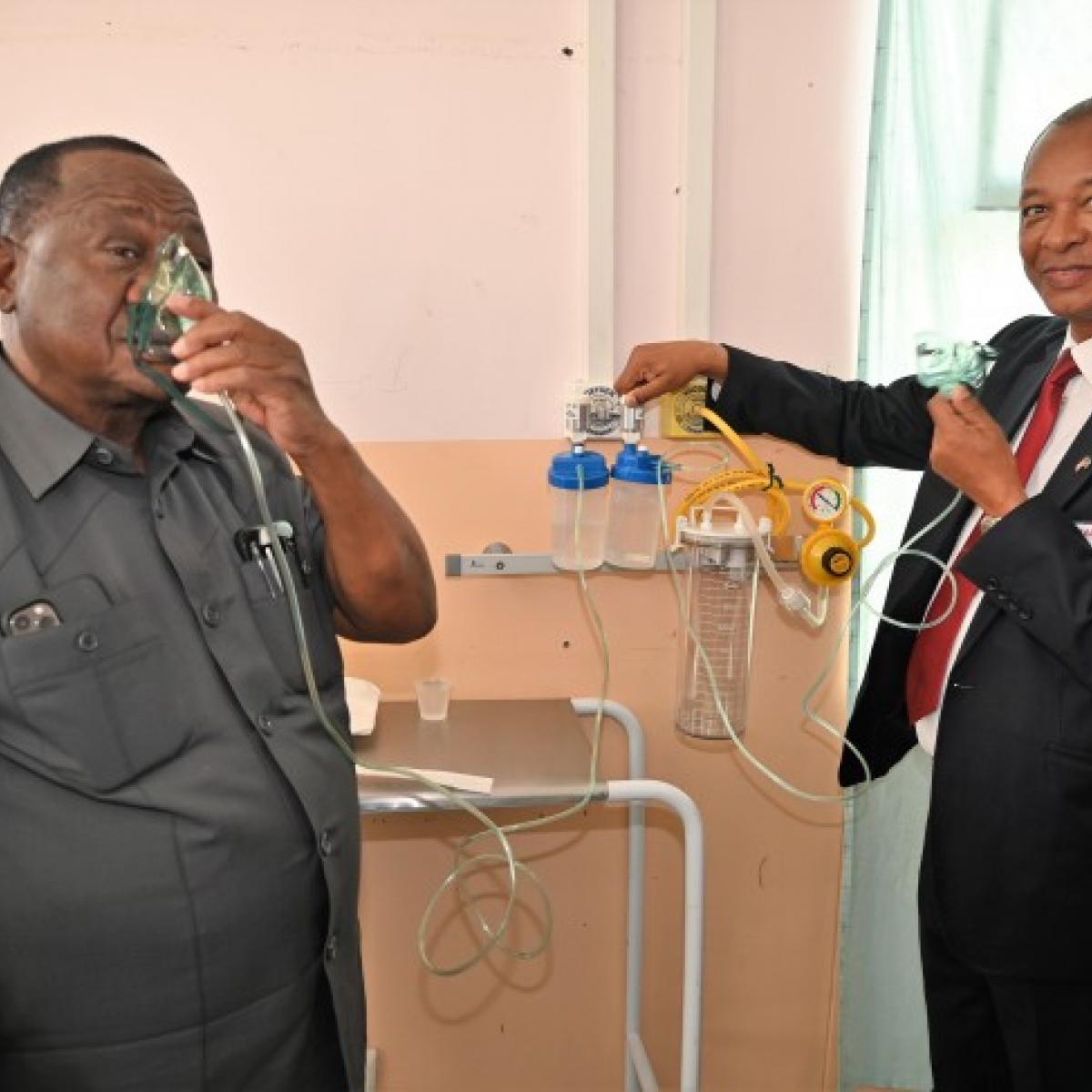 Dr. Kalumbi Shangula, Minister of Health and Social Services and Dr. Abeje Zegeye, Acting Health Office Director at USAID Namibia, demonstrating that oxygen arrives from the new plant at the hospital wards.