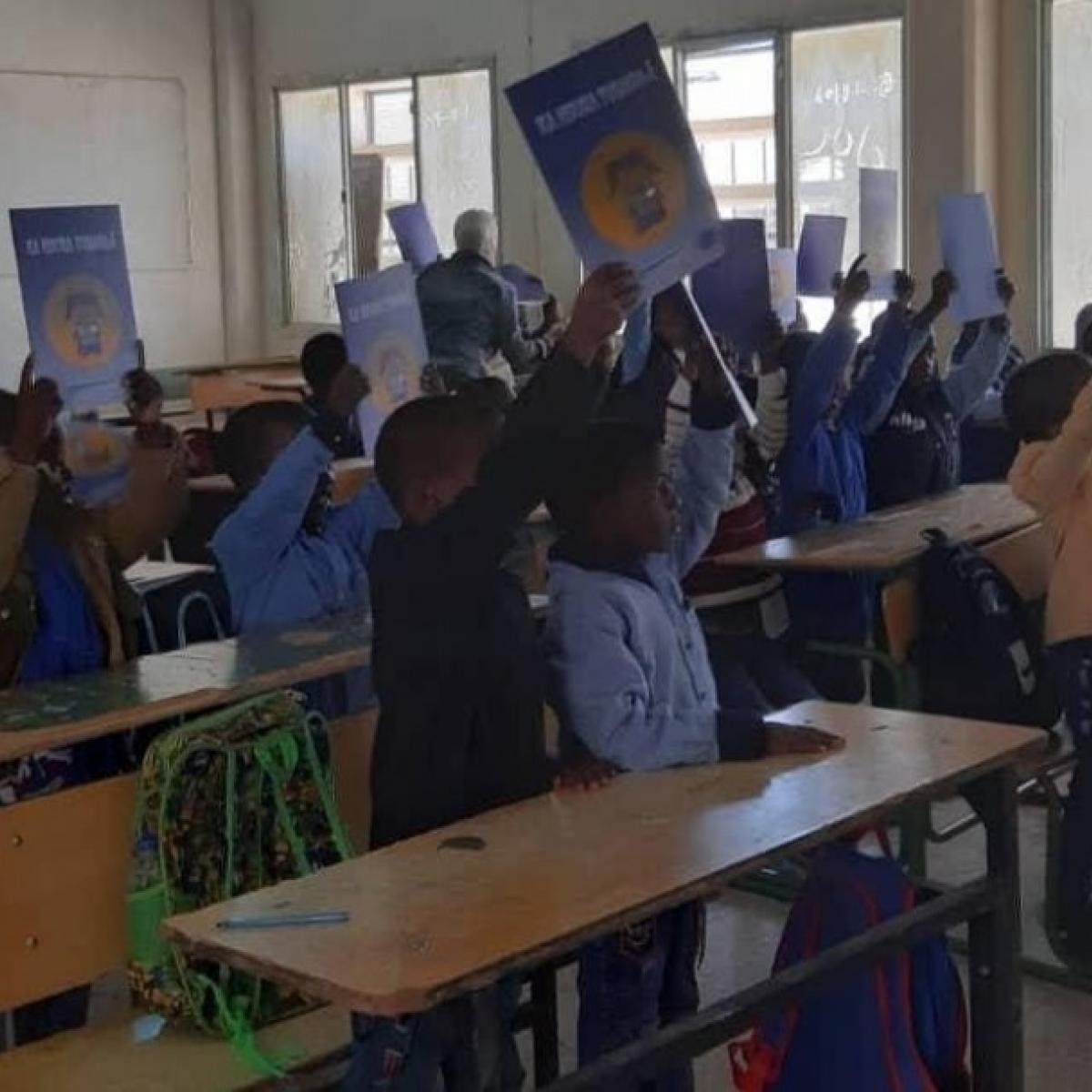 Students at a school im Murzog celebrate the arrival of their textbooks and workbooks in December, 2019.