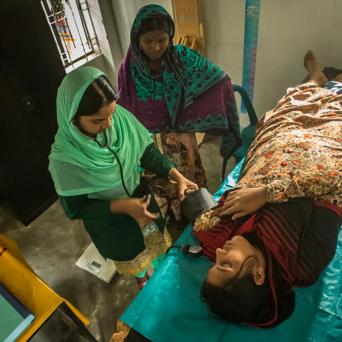 Women helping a patient.