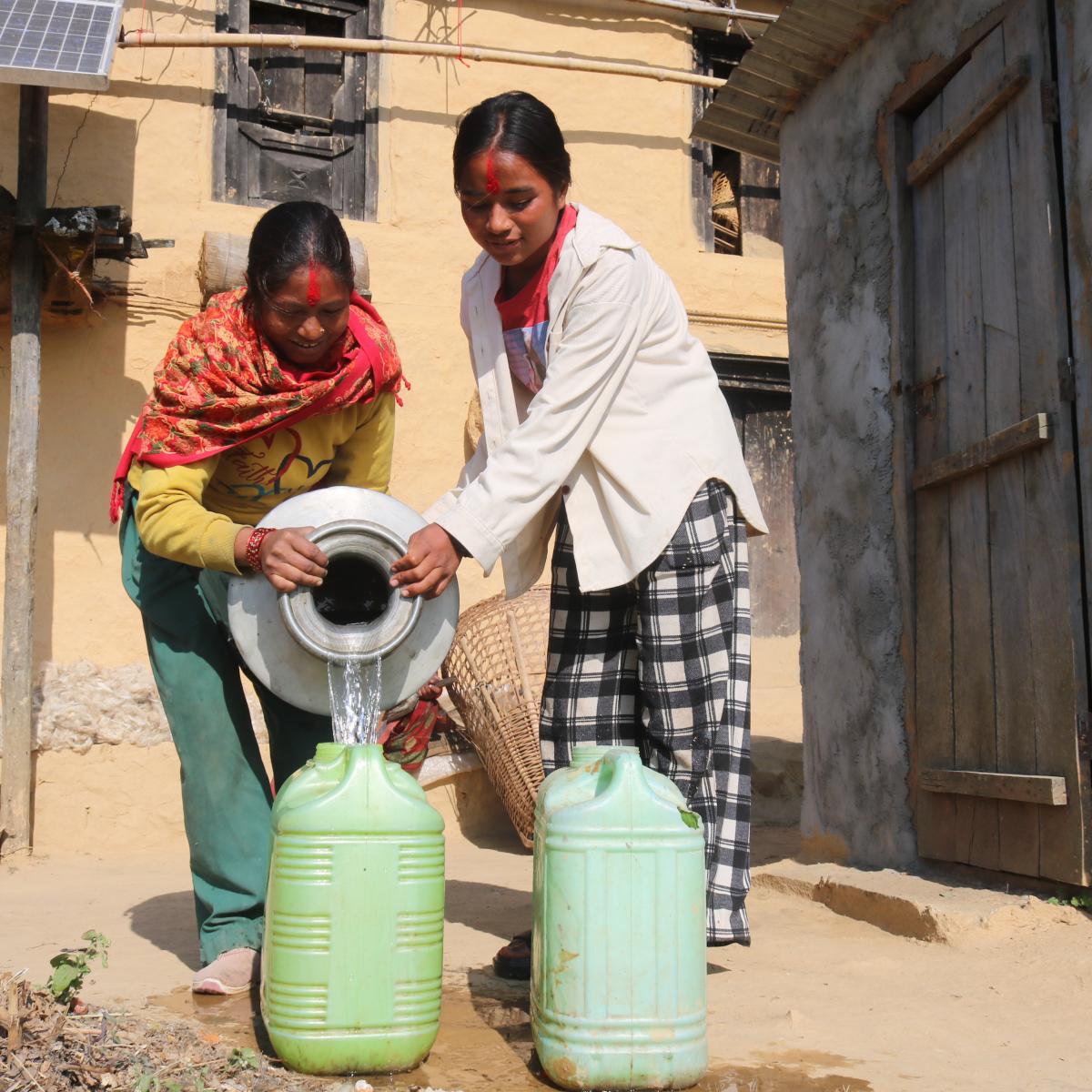 Sangita and her sister-in-law are working to fill the water pots at their home in Pokharikanda. Many households in her village used to spend hours each day fetching water. Now they have a solar-lifting water supply and sanitation system thanks to the USAID Karnali Water Activity and its partnership with the local government. 