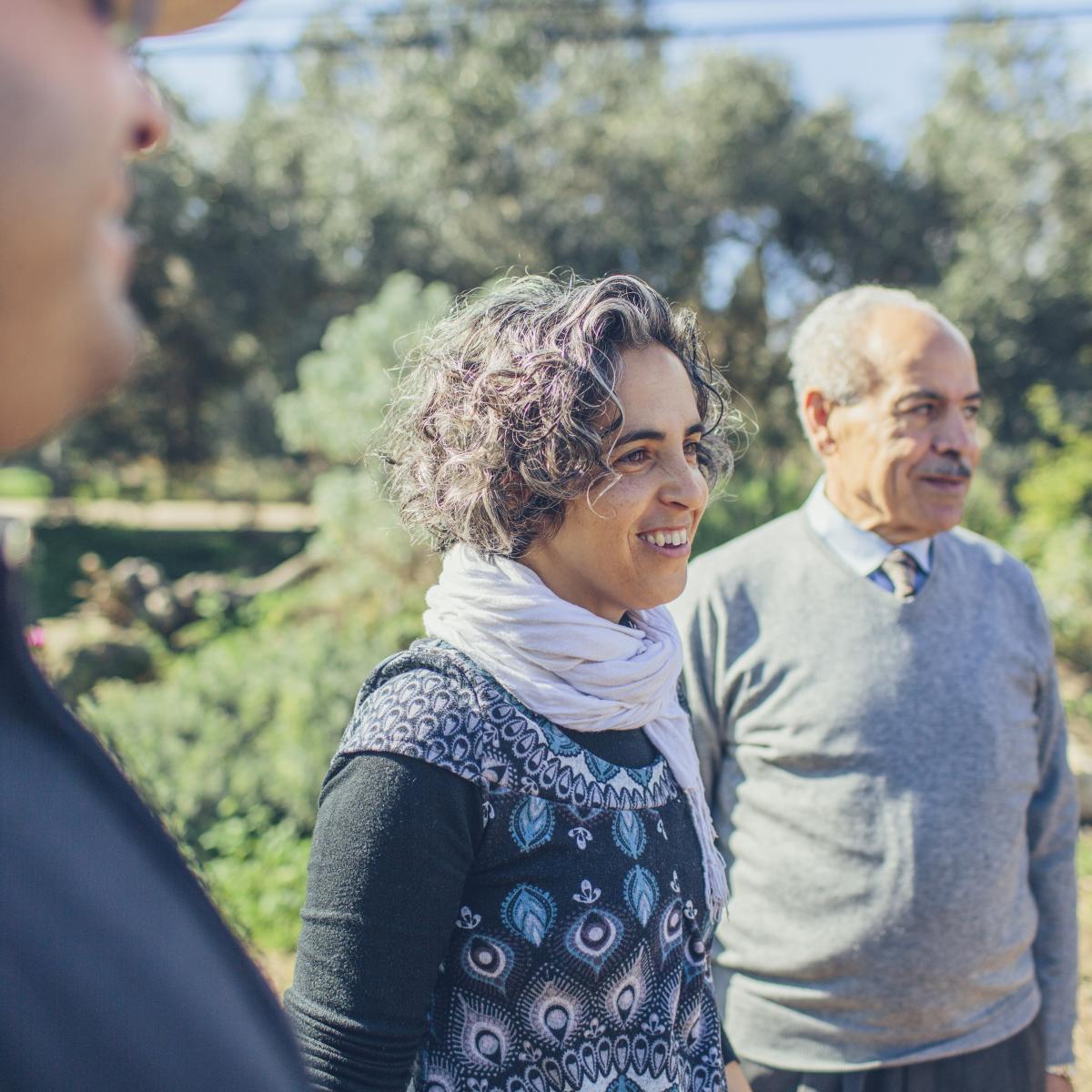 Ayala Noy Meir (left) and Khaled Hassan Hussein Yaseen Al-Juneidi (right) walk through an olive grove together.