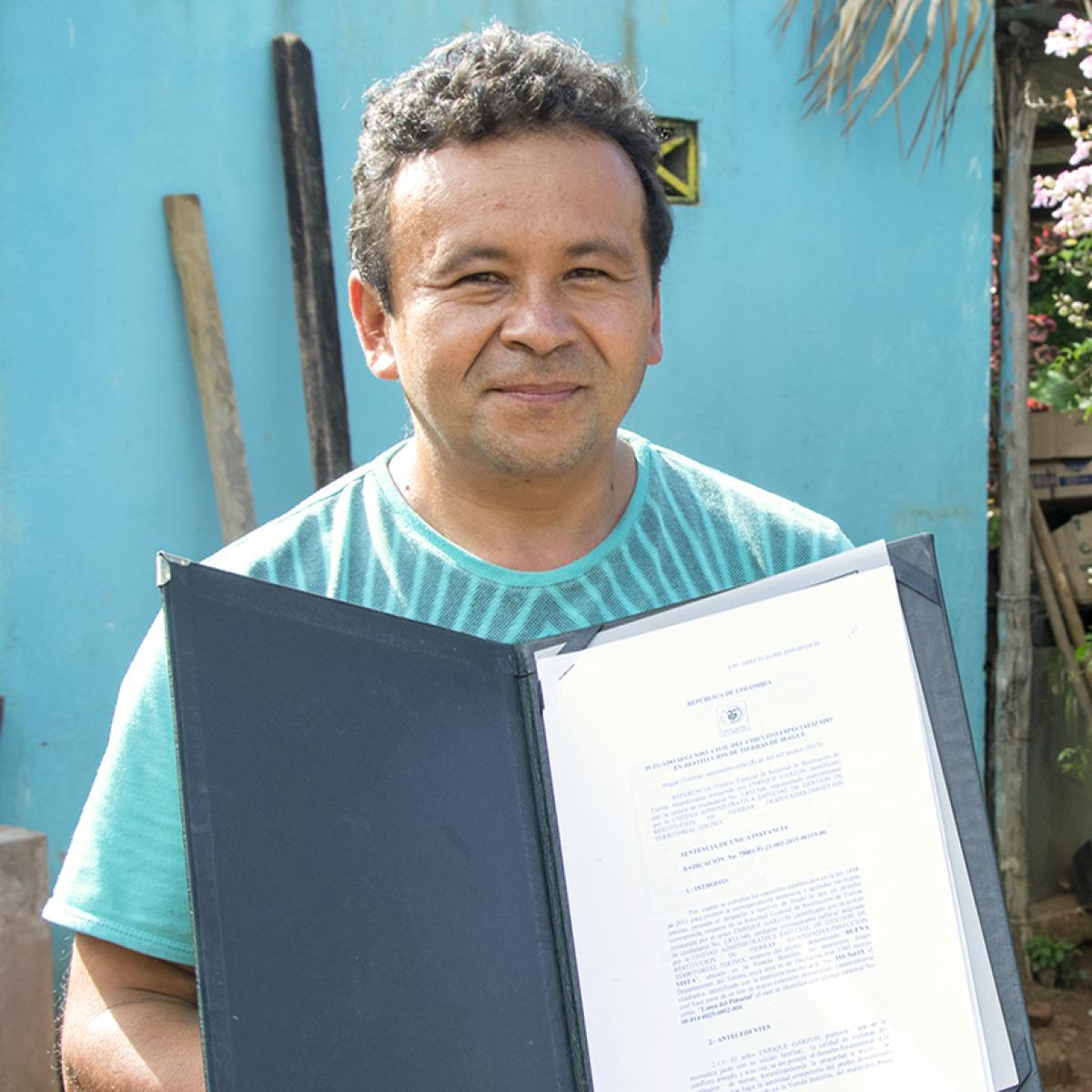 Man holding up a land title.