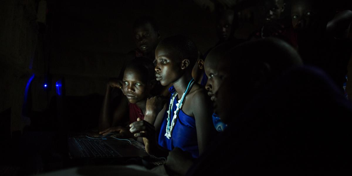 A woman using her solar powered light to read at night in the dark.