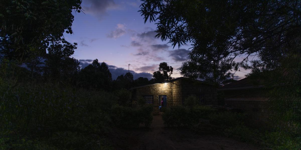 A home in Tala, Kenya just before sunrise with a light on outside the front door.