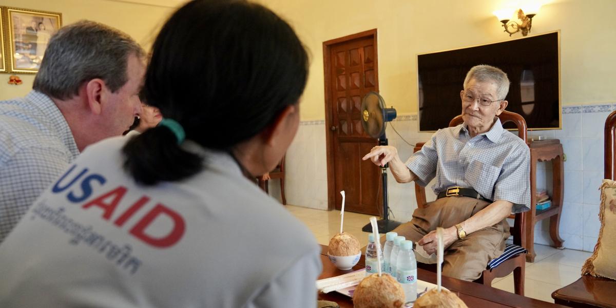 Yeang Chheang speaks with USAID and U.S. President’s Malaria Initiative staff at his home in Phnom Penh.