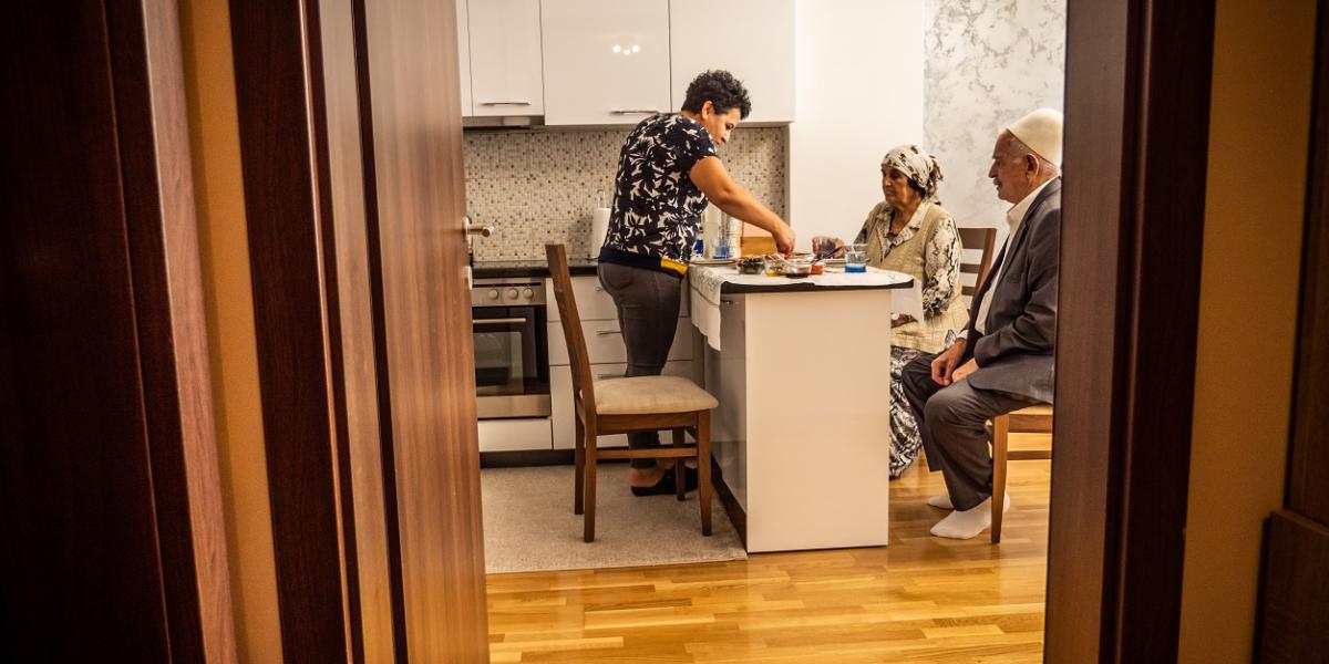 Three people eat at a kitchen counter