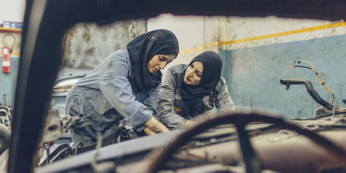 The two sisters work together in the auto shop to repair a broken car.