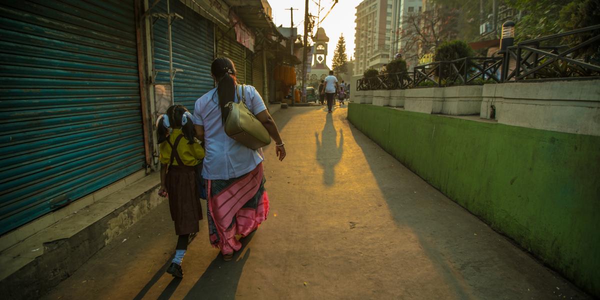 A woman and her daughter walk in a neighborhood.