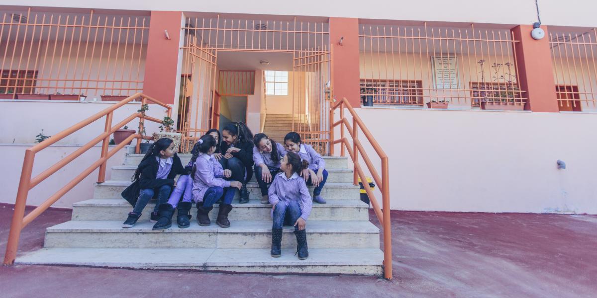 Students sit on the school steps and chat