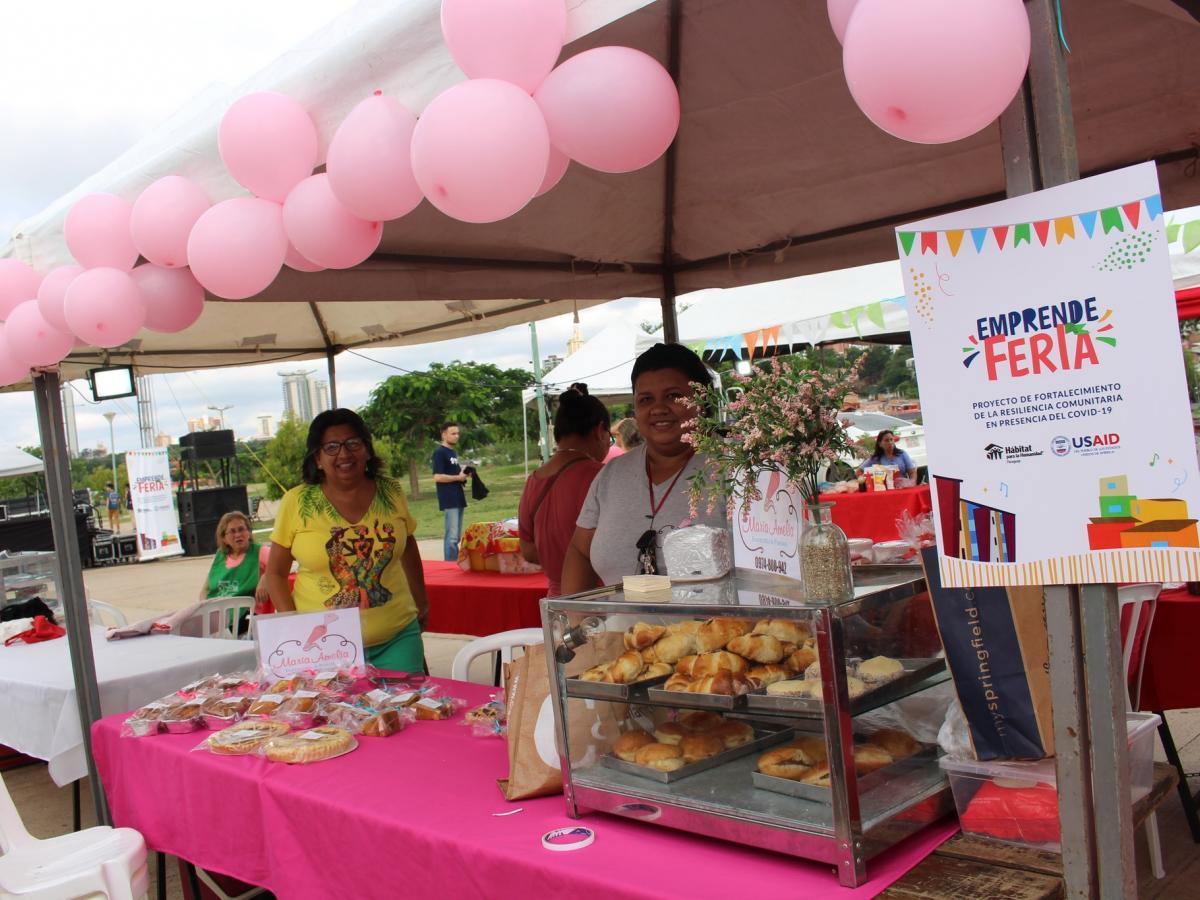 A participant displays homemade desserts and sweets for sale at an entrepreneurship fair.