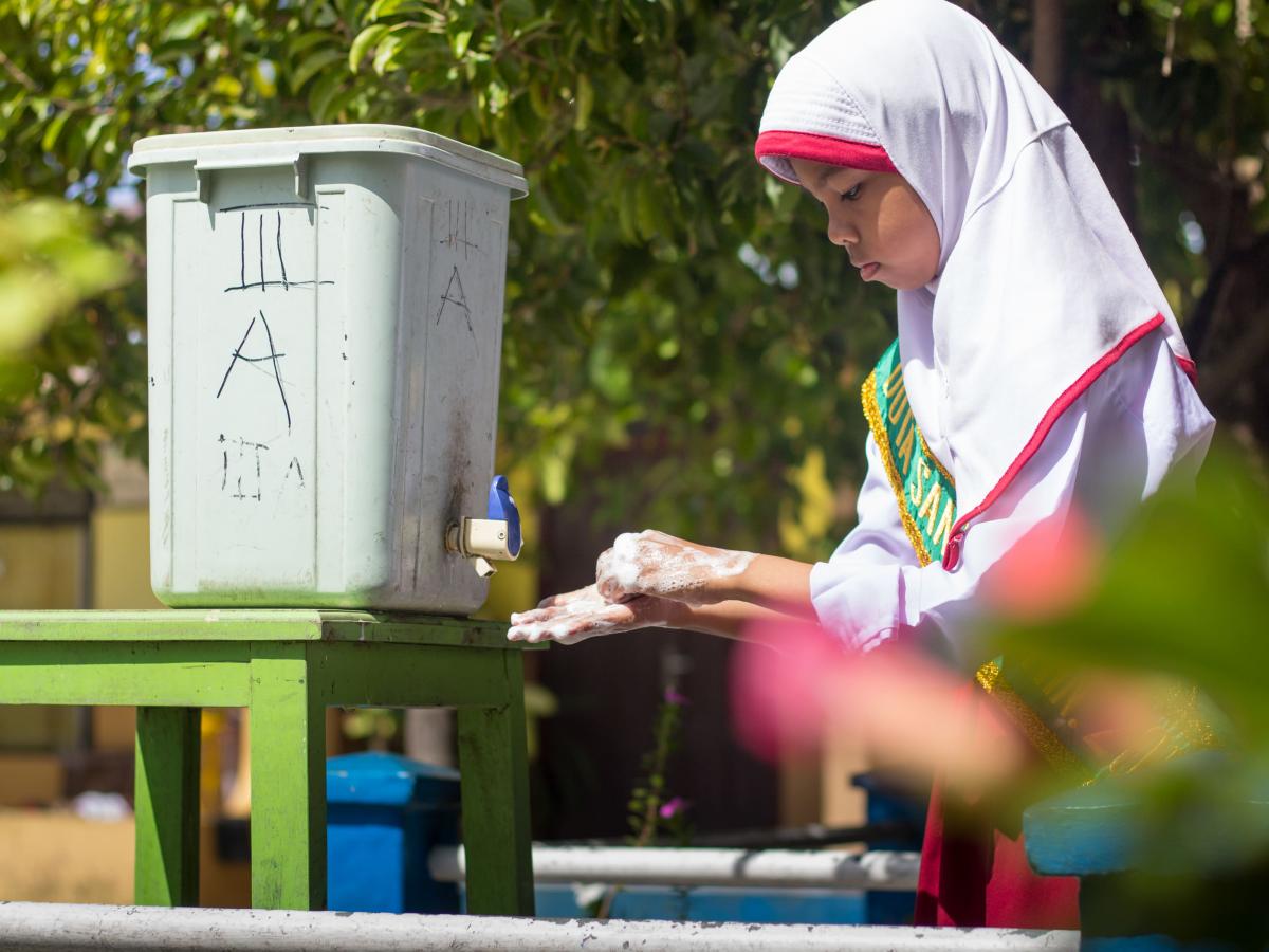 A girl is washing her hands with clean running water