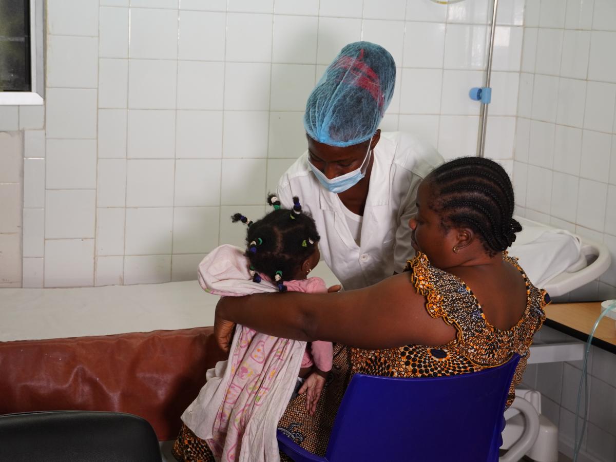 health worker giving vaccines to newborn