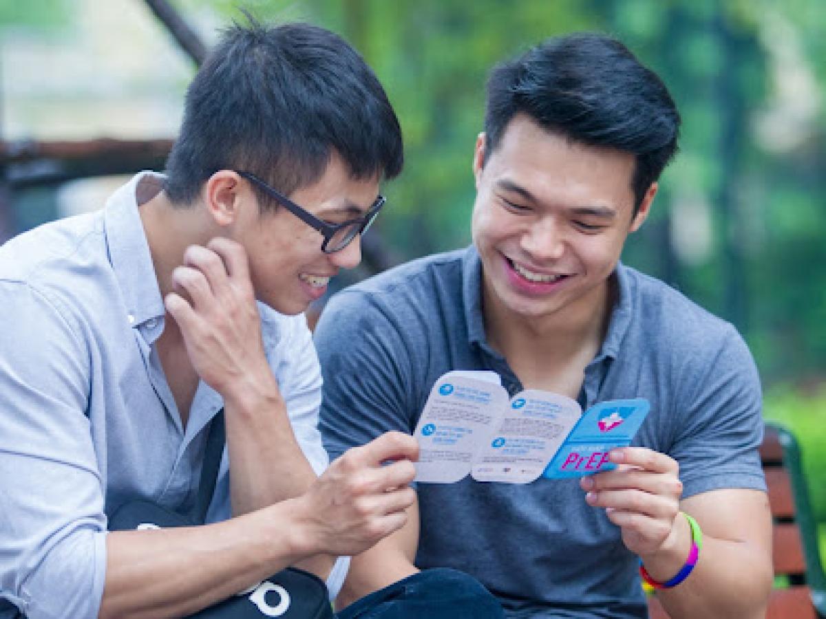 Two young men who have sex with men (MSM) in Vietnam read a leaflet about HIV pre-exposure prophylaxis (PrEP) and available PrEP services. 