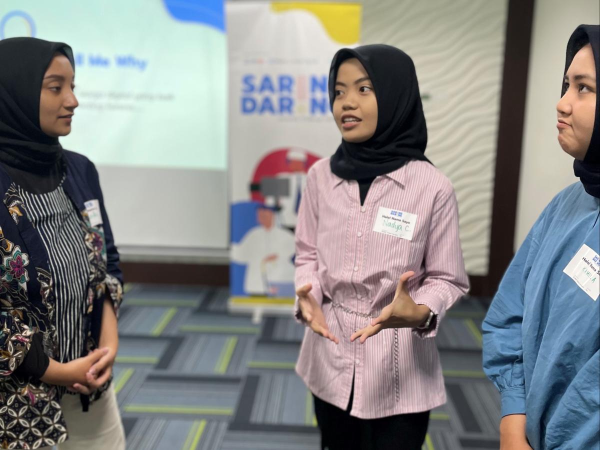 Three female participants at a University Challenge workshop discuss digital literacy