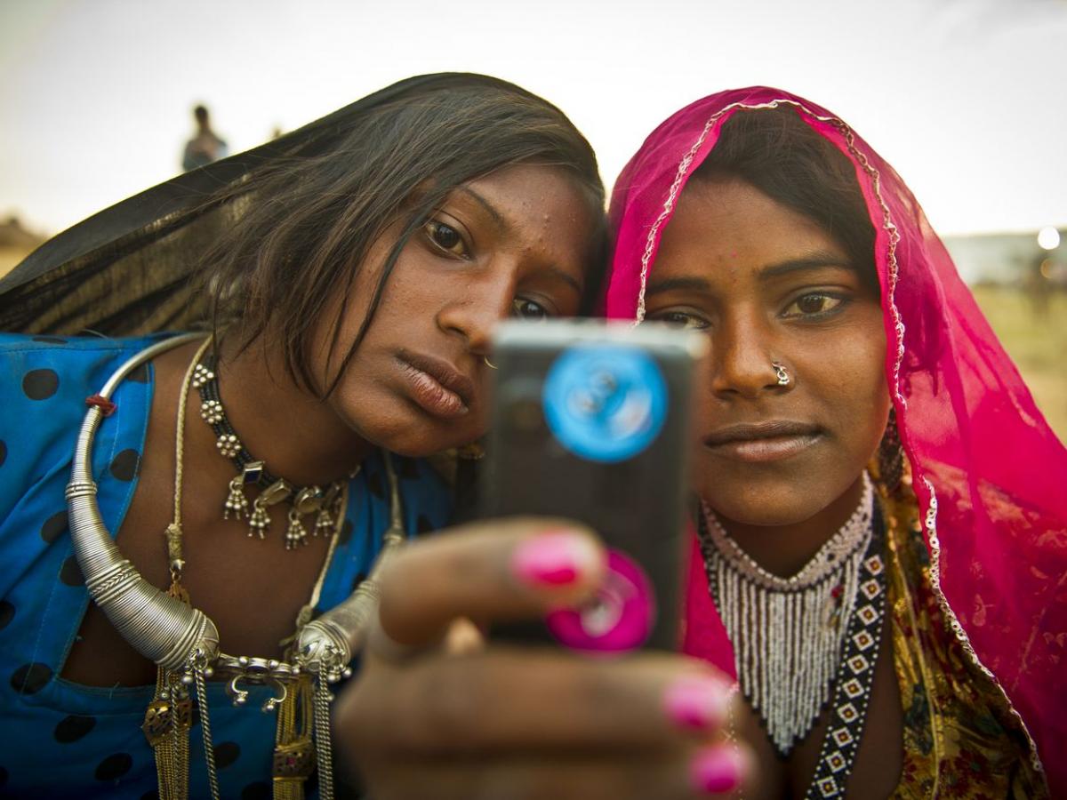A pair of women look at a handheld device