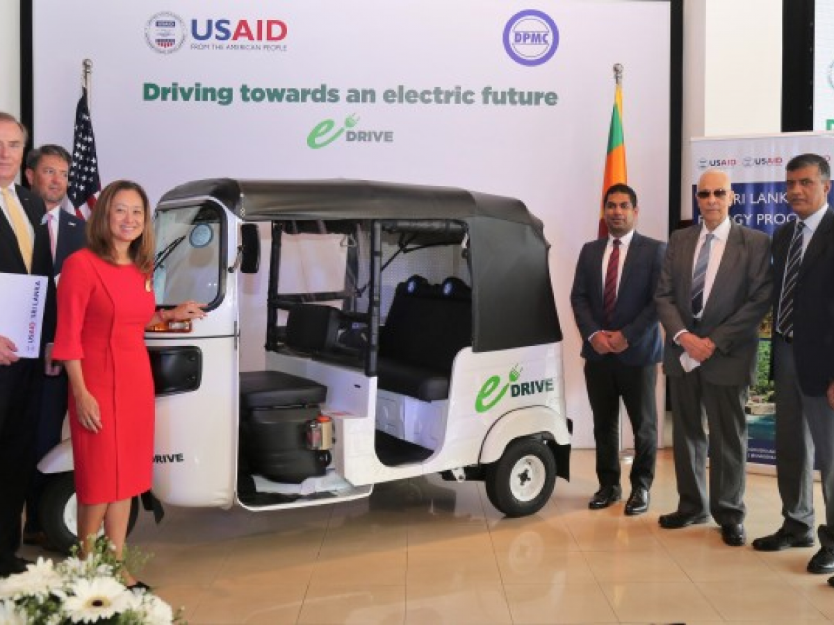 Representatives from USAID Sri Lanka and David Pieris Motor Company standing with a tuk tuk