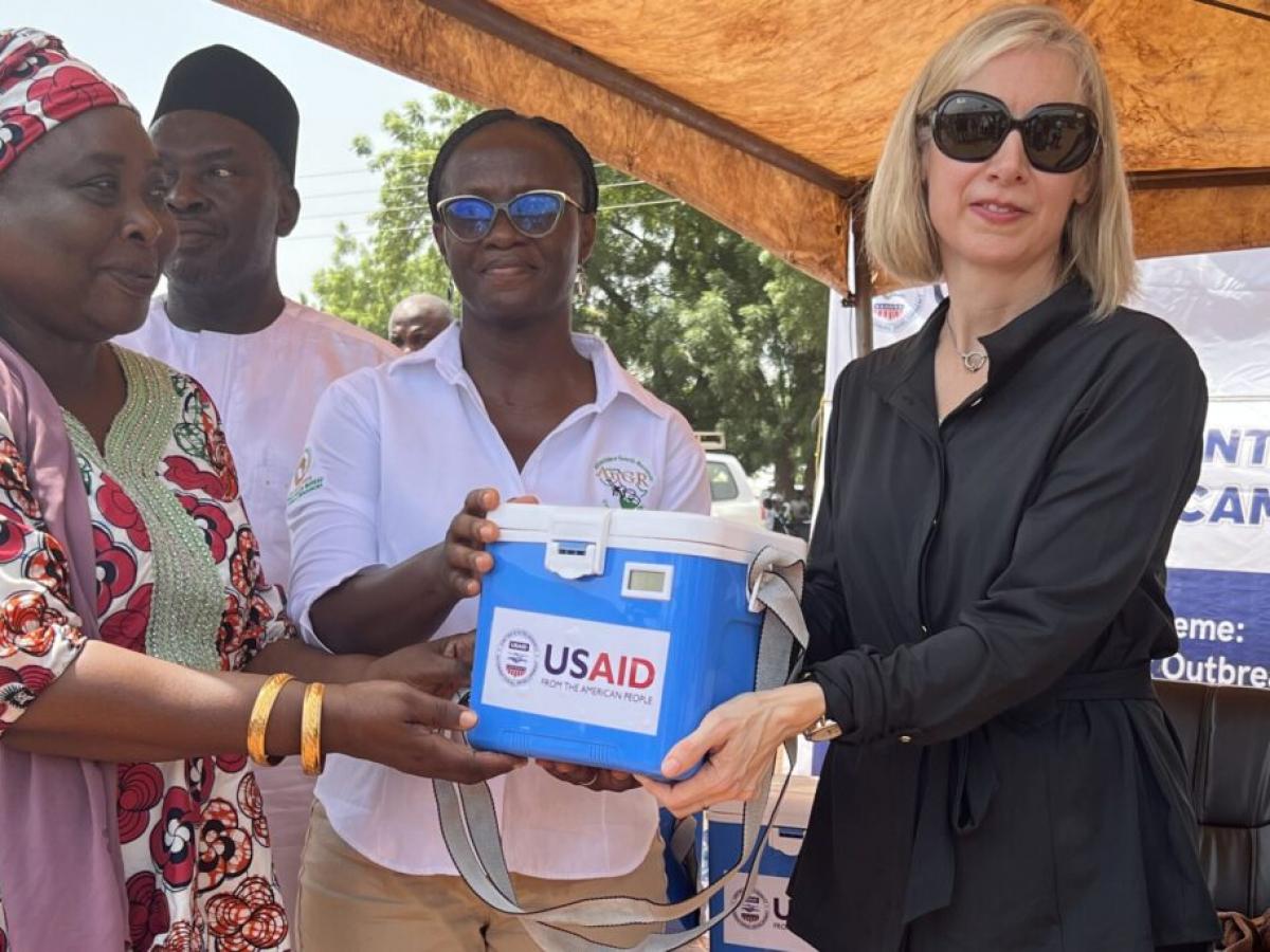 USAID/Ghana Mission Director, Kimberly Rosen handing over donated anthrax vaccines to the Northern Region director of agriculture (left), and the deputy director of the veterinary service directorate (center).