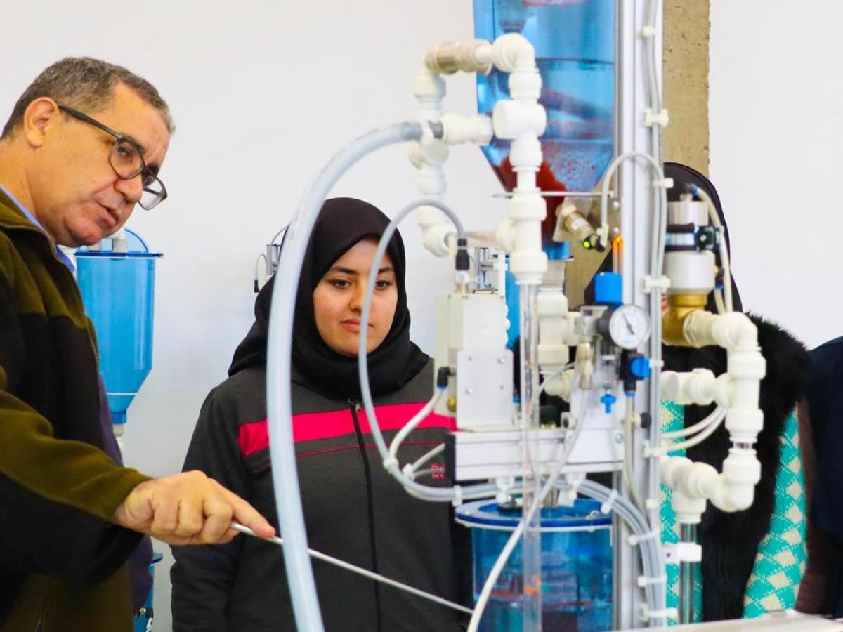 Photo of a Moroccan instructor and young woman trainee in front of water managment equipment 