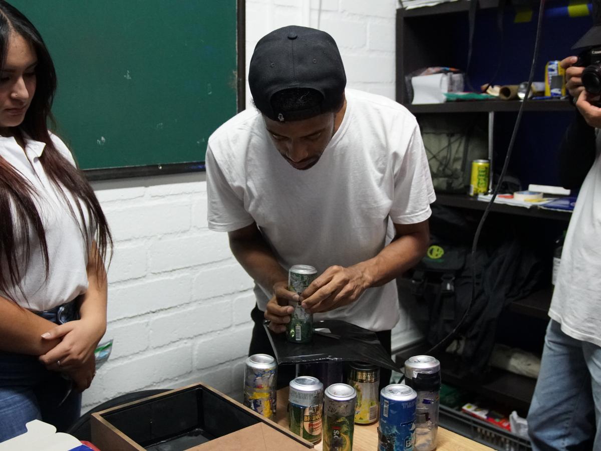 Rulos, one of the Veanvé workshop leaders, teaches students to make pinhole cameras using aluminum cans. 
