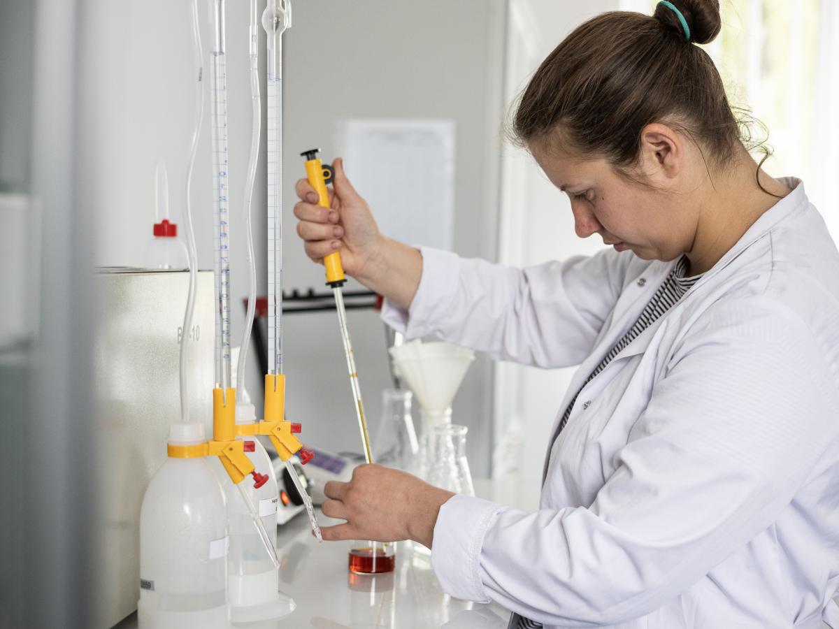 A woman uses laboratory equipment to text the quality of potato starch.