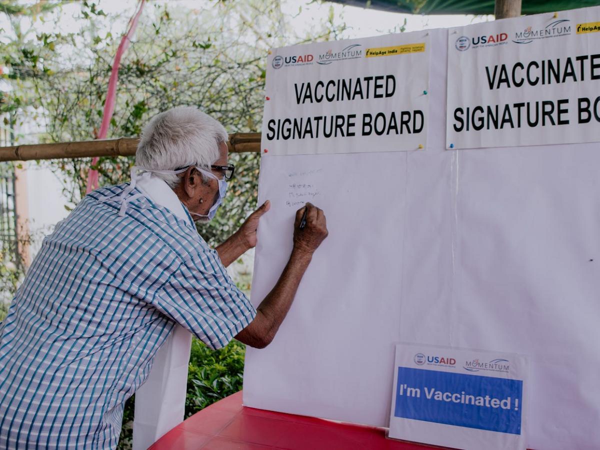 A community member in Assam, India, participates in a signature campaign after receiving their first COVID-19 vaccine.