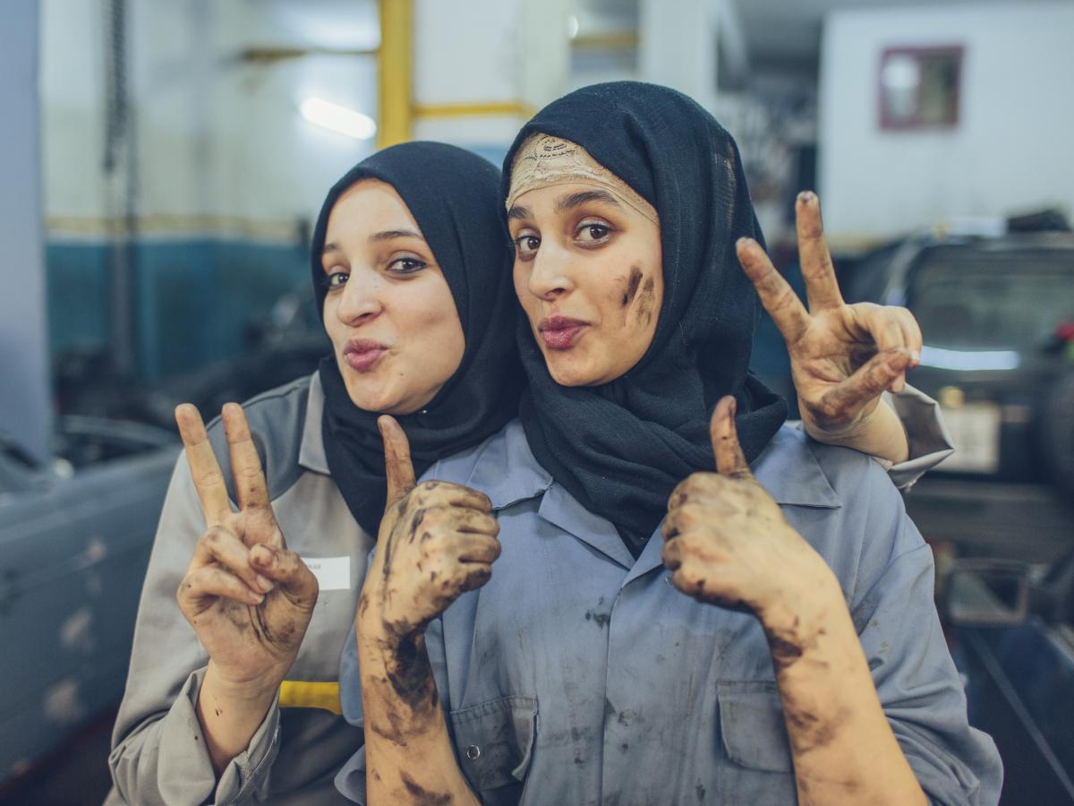 Najlae (right) and Rajae (left) pose together in an auto body shop.