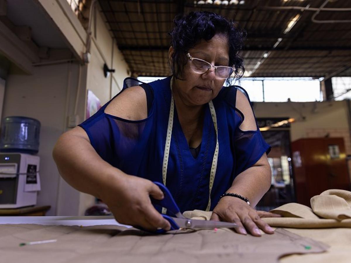 A Peruvian artist cuts out patterns for a fashion design.