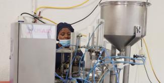 Josiane operating a yogurt processing machine at Masaka Creamery in Rwanda. 