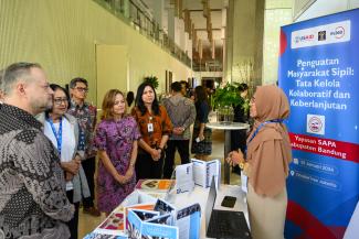 Wakil Direktur Misi USAID Indonesia Erin Nicholson bertemu dengan salah satu mitra masyarakat sipil, Yayasan SAPA dari Kabupaten Bandung, di pameran yang menampilkan mitra OMS USAID MADANI.