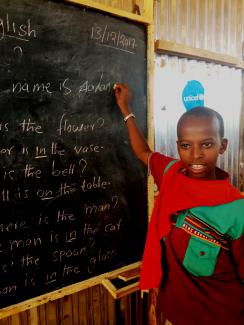 Adan Kero proudly writes his name in English on the chalkboard. 